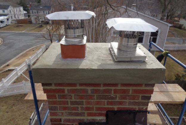 Two chimneys are sitting on top of a brick chimney