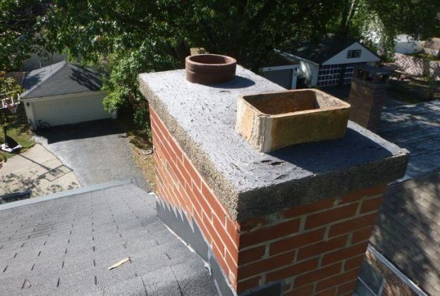 A brick chimney is sitting on top of a roof