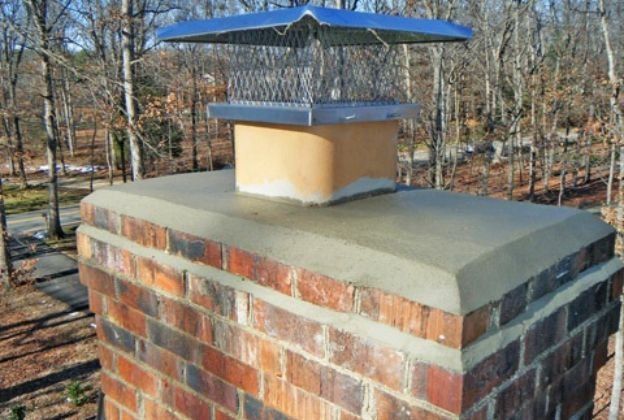 A brick chimney with a blue cover on top of it.