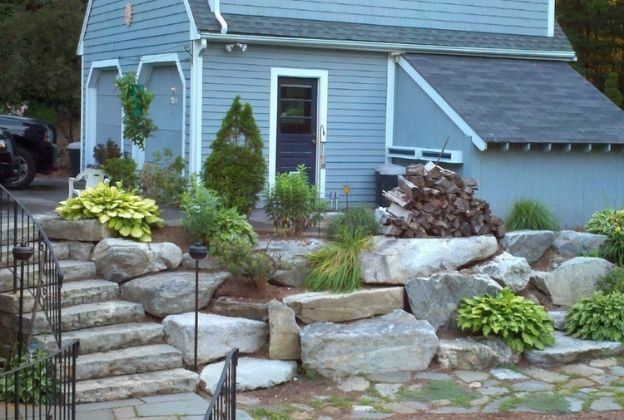 A small house with stairs and rocks in front of it