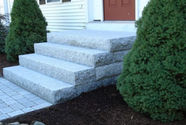 A set of stairs leading up to a house with trees in the background.
