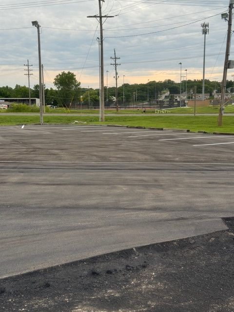 A parking lot with a lot of power lines in the background