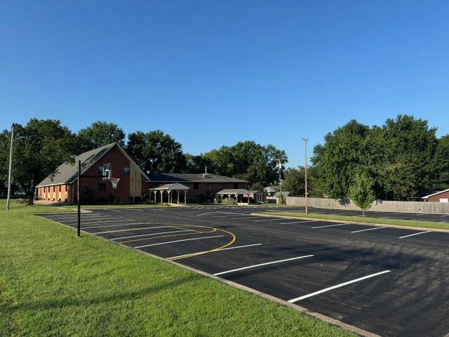A parking lot with a brick building in the background