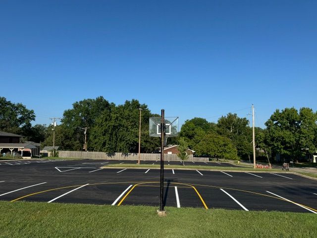 A basketball hoop is in the middle of a parking lot