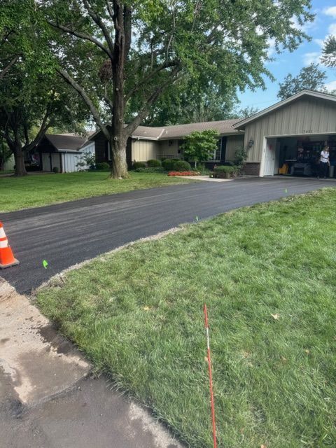 A driveway is being paved in front of a house