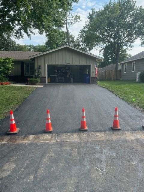 A driveway with orange cones in front of a house