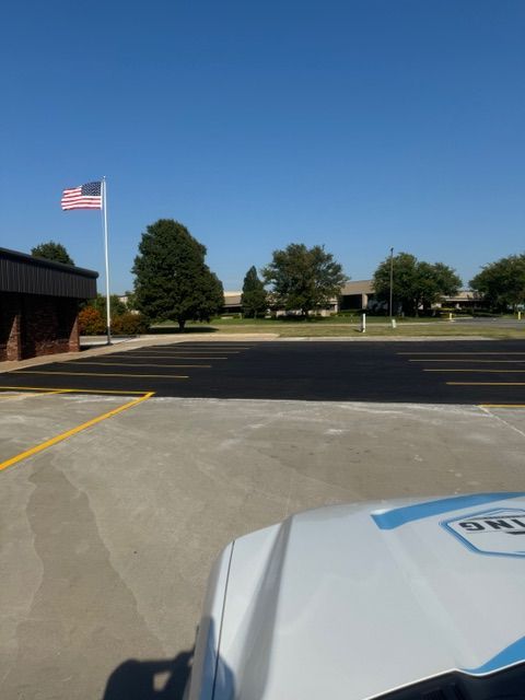 A police car is parked in a parking lot with an american flag in the background