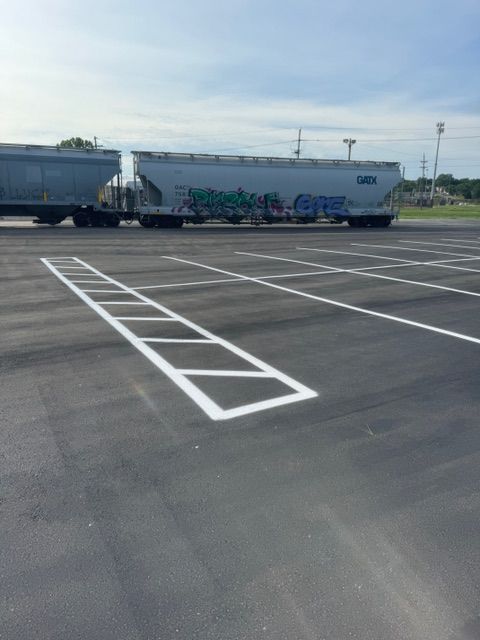 A train is parked in a parking lot with graffiti on it