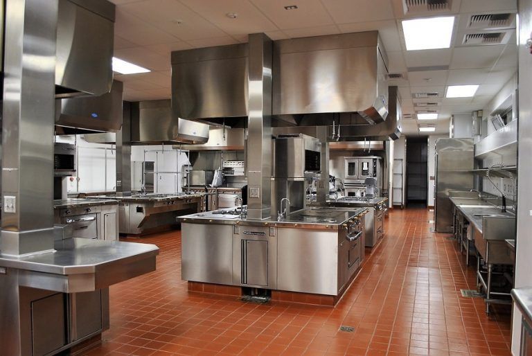 Commercial kitchen with stainless steel equipment and red tile floor