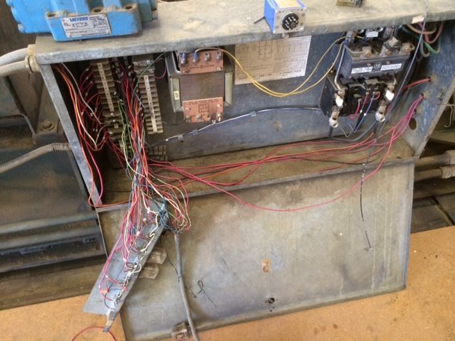 Open electrical panel with exposed wiring and components inside a metal cabinet