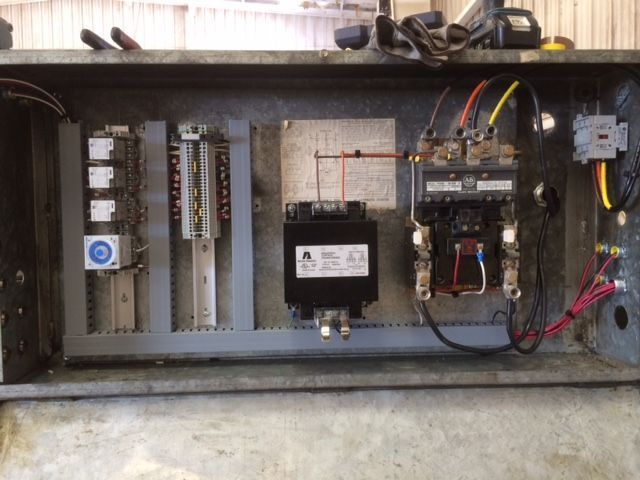 Open electrical control panel with wiring, breakers, and components inside a metal enclosure