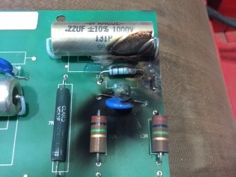 Close-up of a green circuit board with capacitors, resistors, and electronic components.