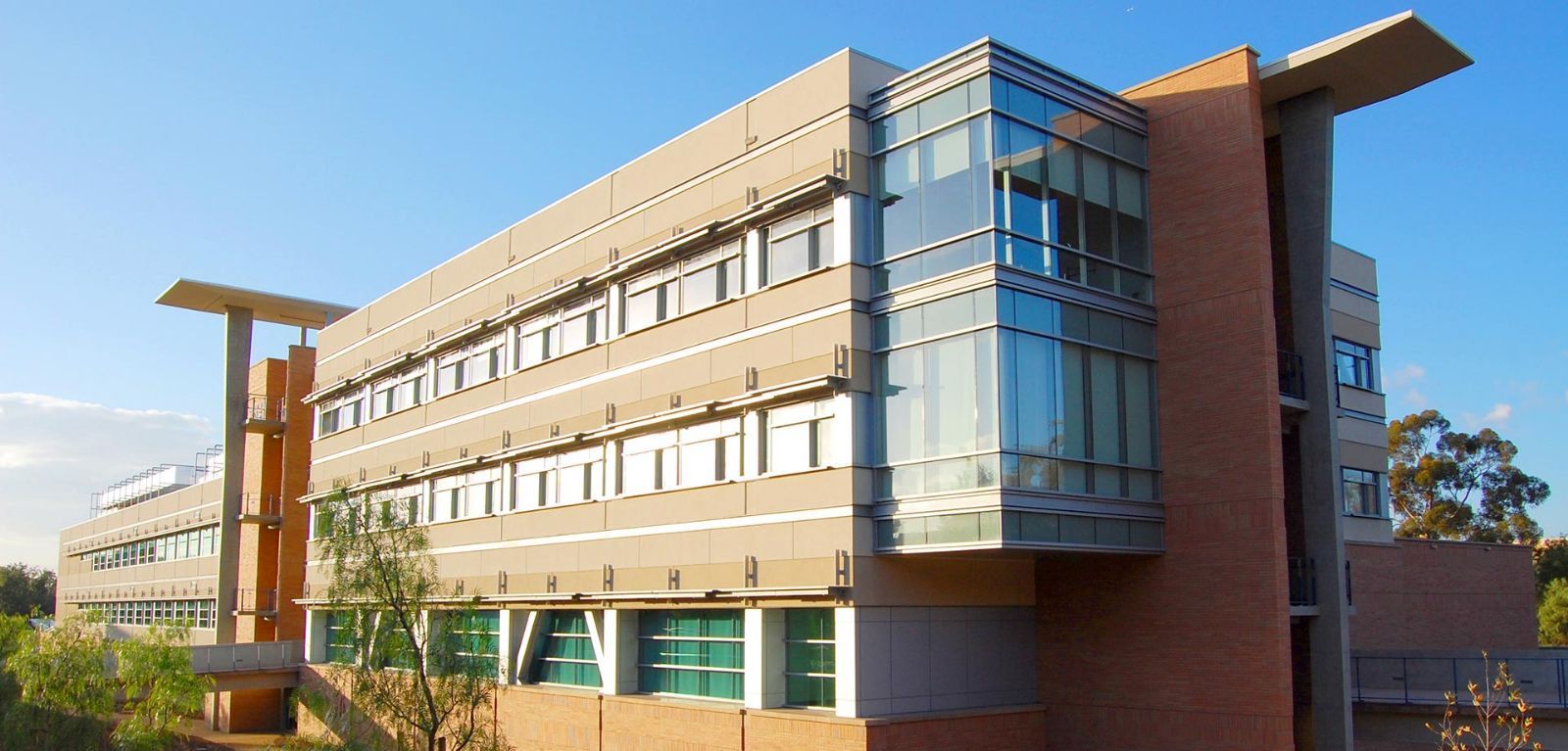 Modern office building with glass corner facade and brick exterior in daylight