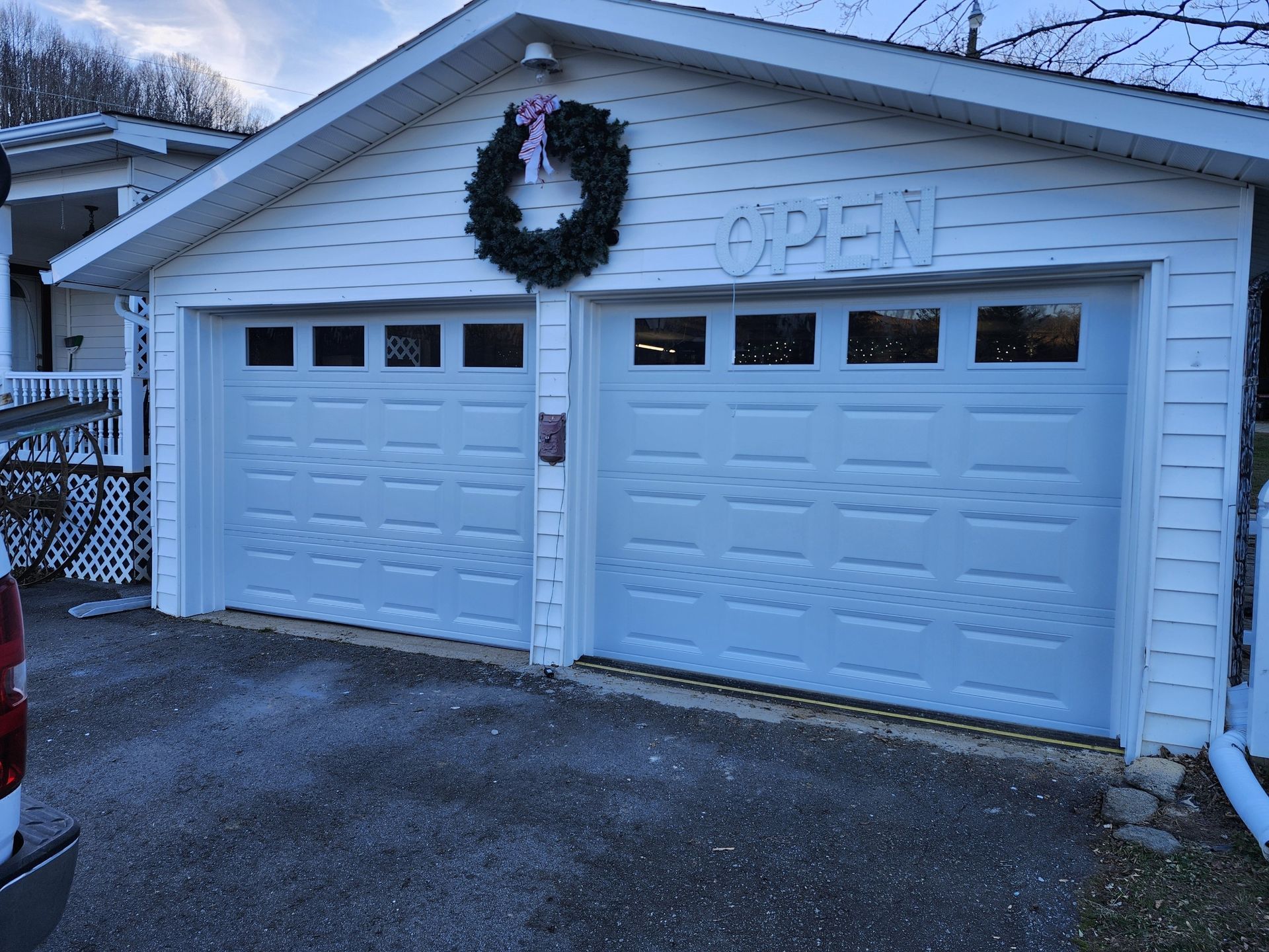 Two-car garage with white doors, wreath, and 