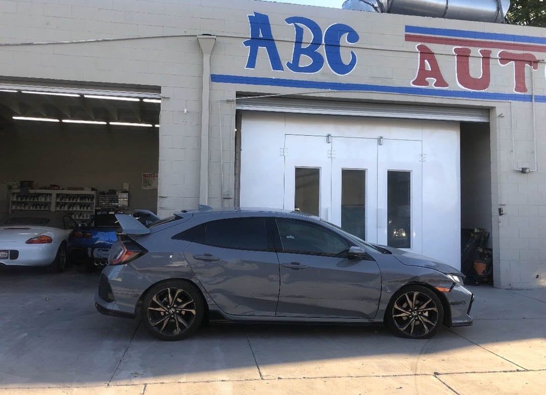 Gray car parked outside of ABC Auto garage.