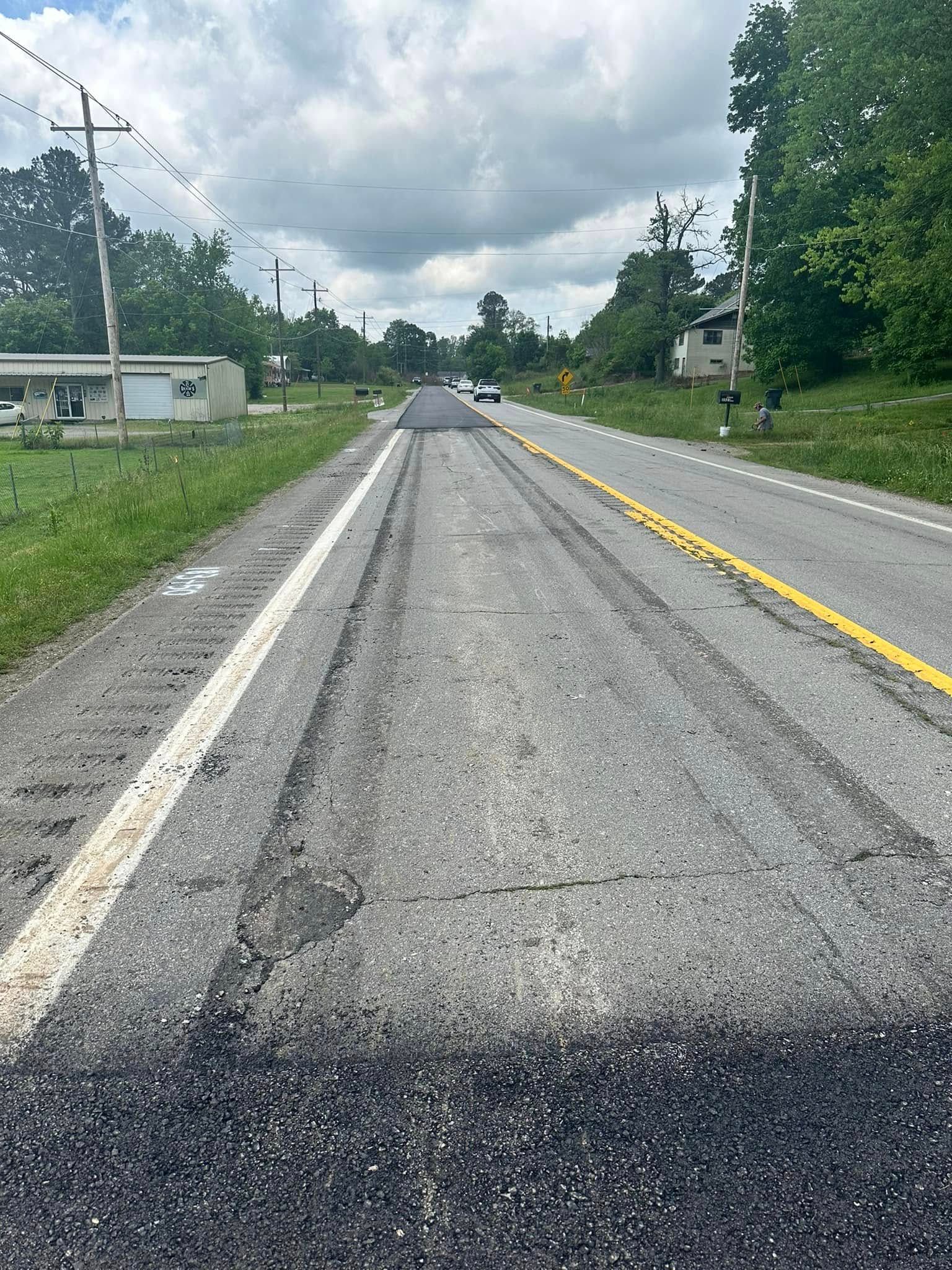 A car is driving down a road with a yellow line on it.