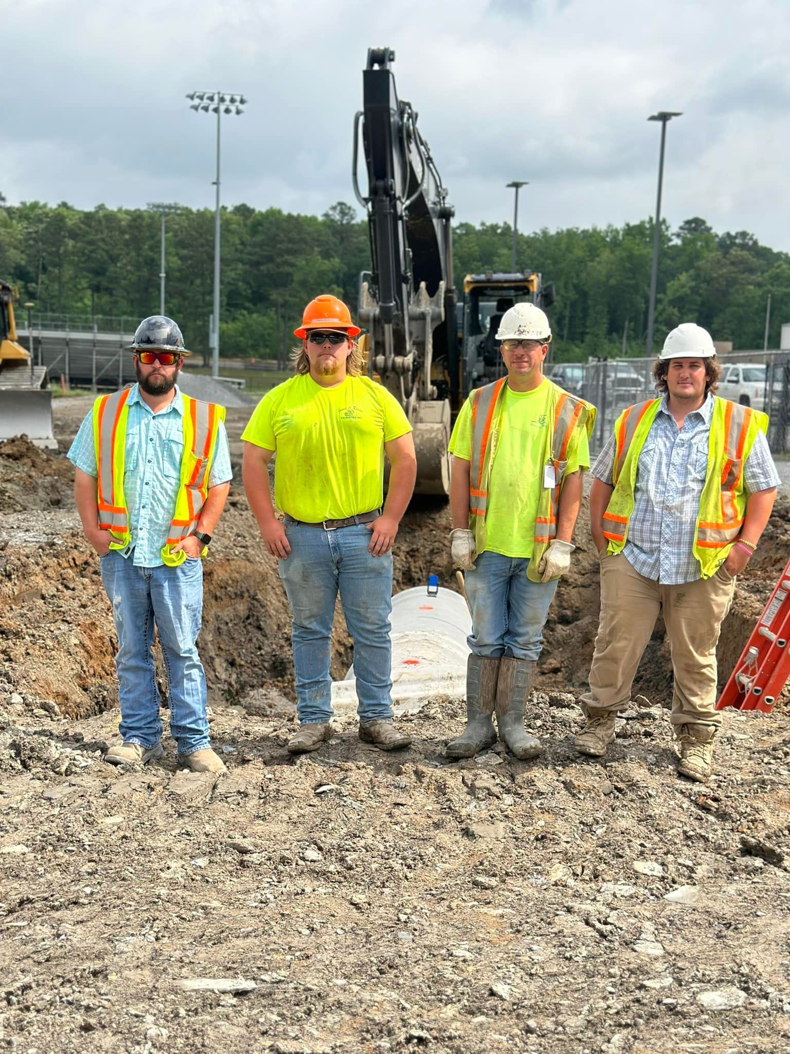 A group of construction workers are posing for a picture on a construction site.