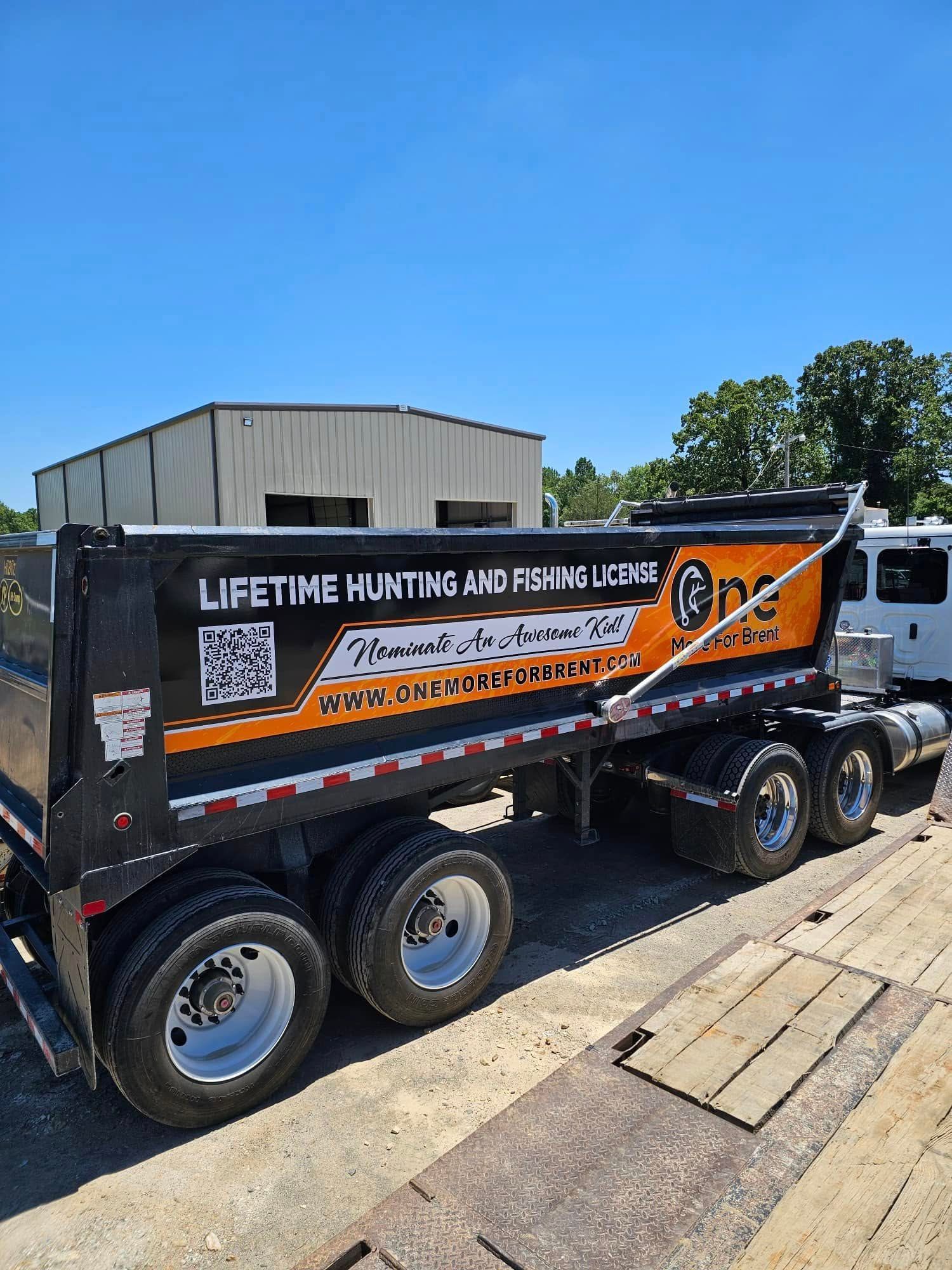 A dump truck is parked in front of a building on a sunny day.
