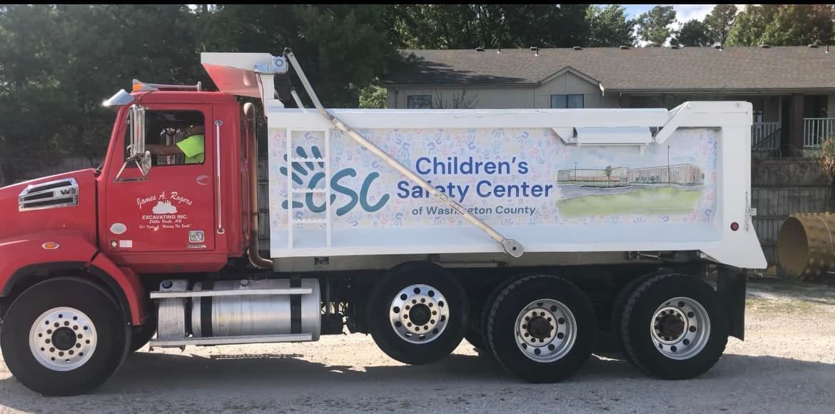 A red dump truck is parked in front of a house.