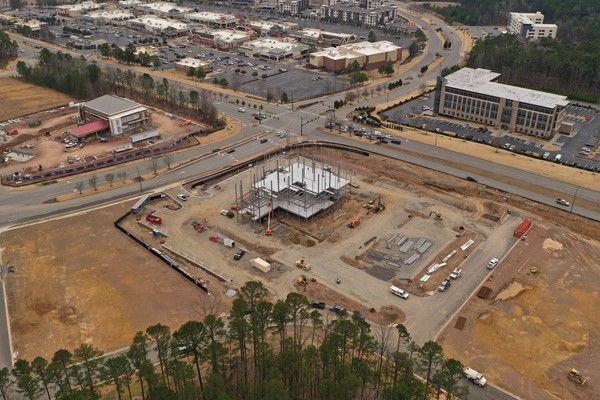 An aerial view of a construction site with a lot of buildings in the background.