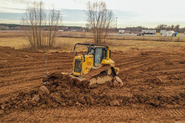 A bulldozer is moving dirt in a field.