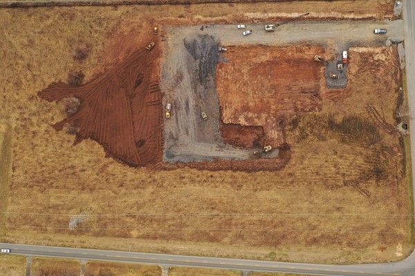 An aerial view of a dirt field with a building in the middle of it.