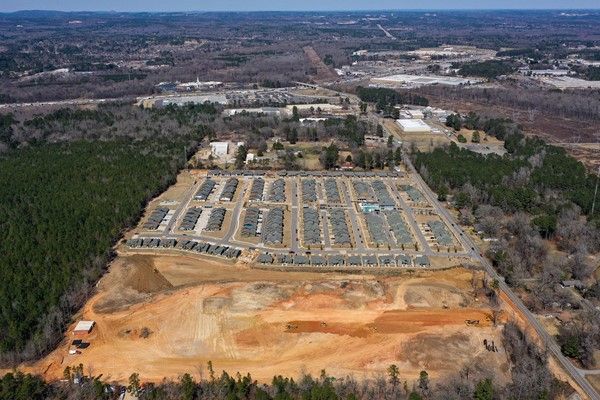 An aerial view of a residential development in the middle of a forest.