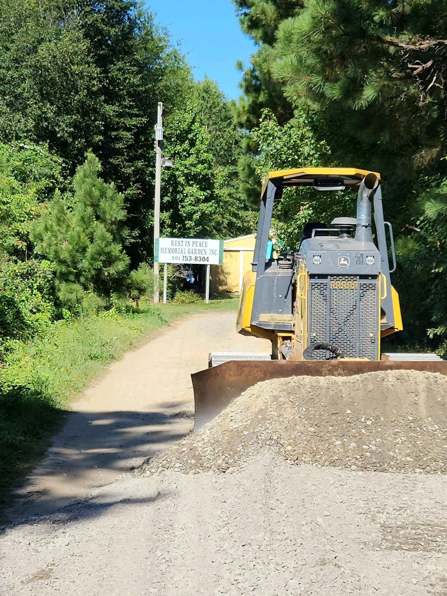 A bulldozer is driving down a dirt road.