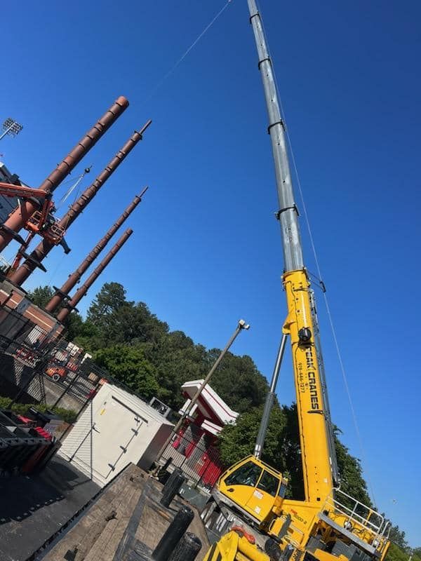A large yellow crane is sitting on top of a truck.