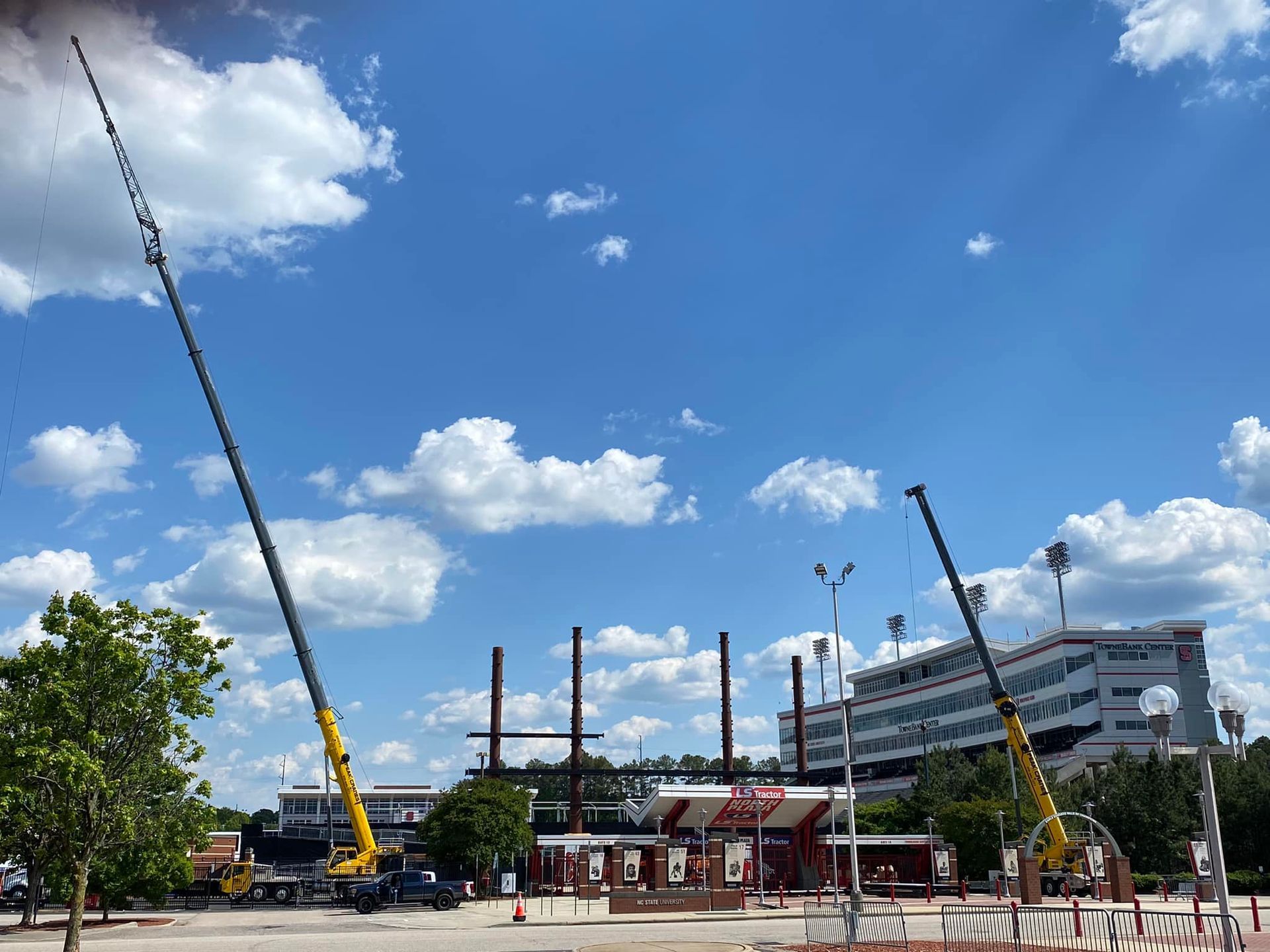 A large crane is being used to build a building in front of a kfc restaurant.
