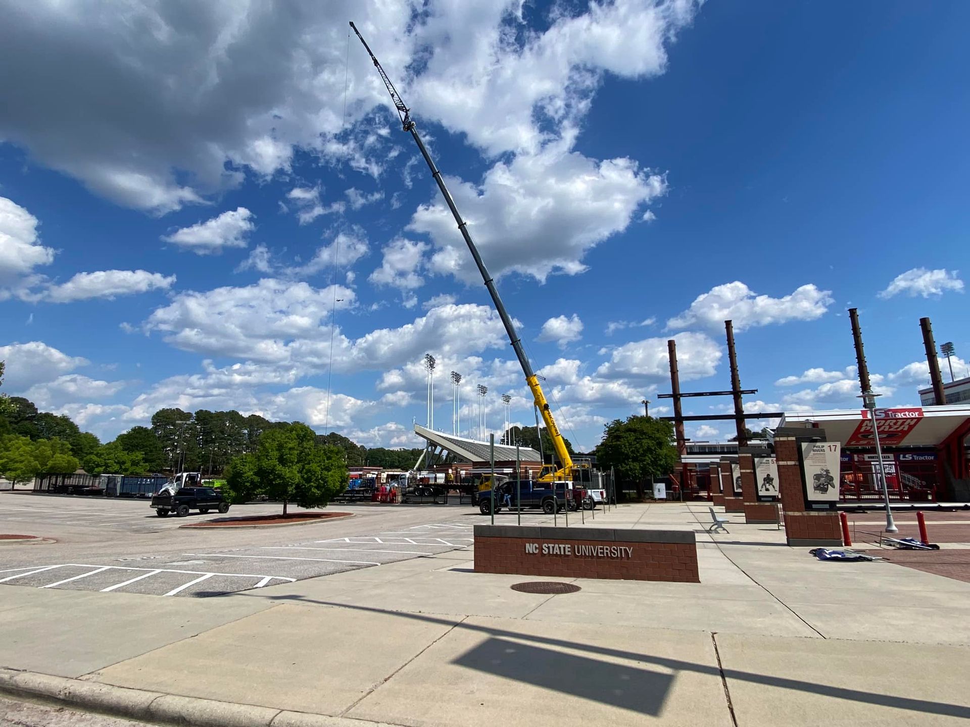 A large crane is sitting in a parking lot in front of a building.