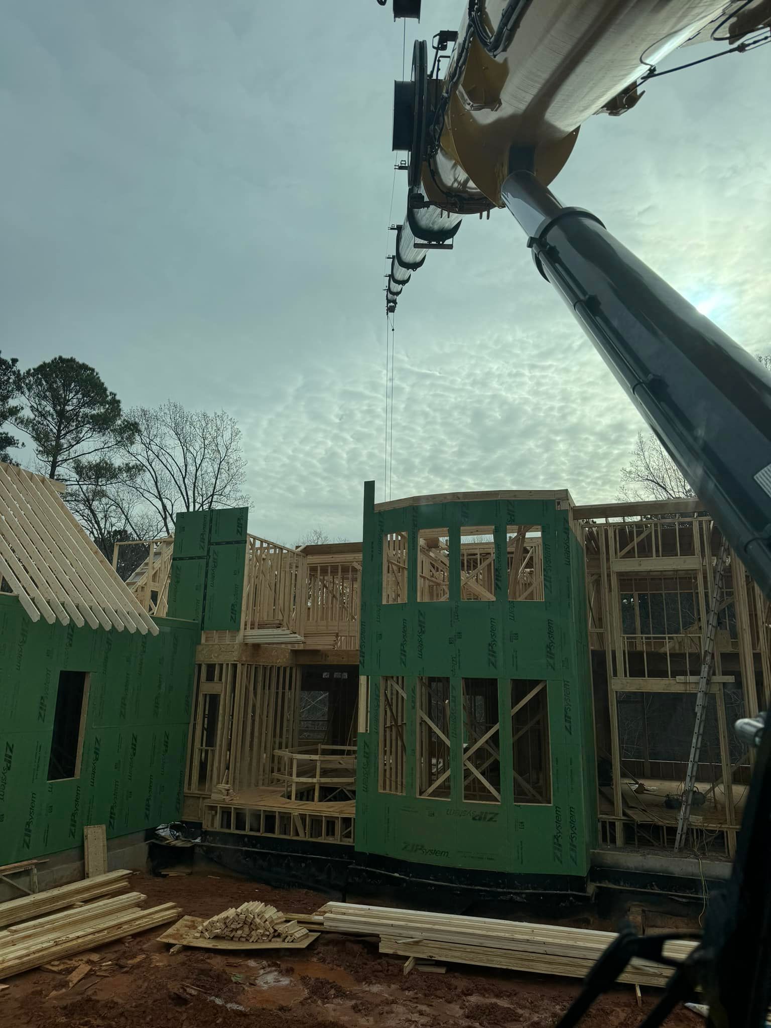 A crane is lifting a piece of wood at a construction site.