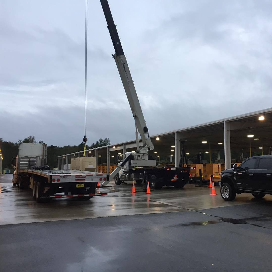 A truck is being towed by a crane in a parking lot
