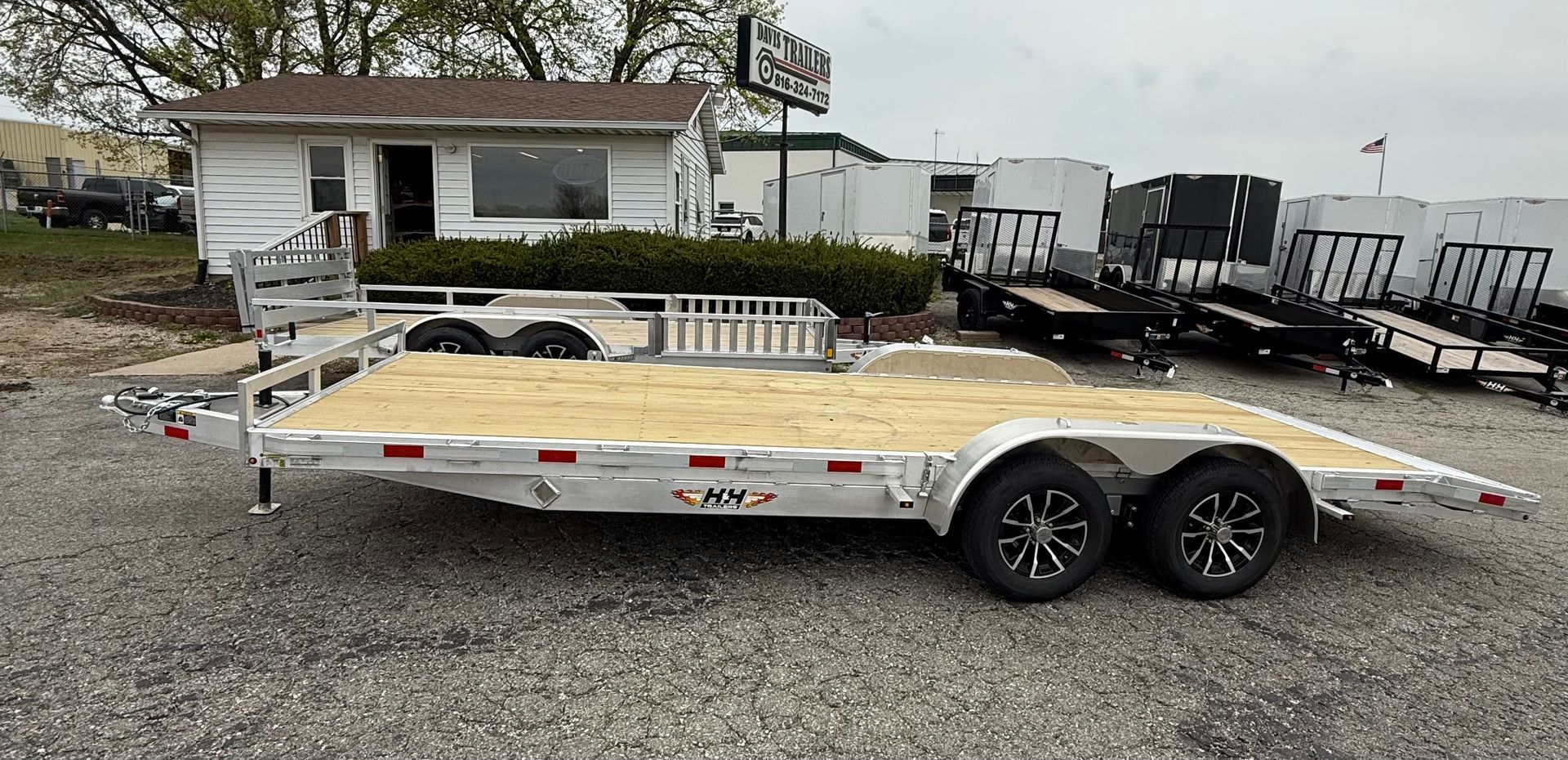 Black flatbed trailer parked on gravel