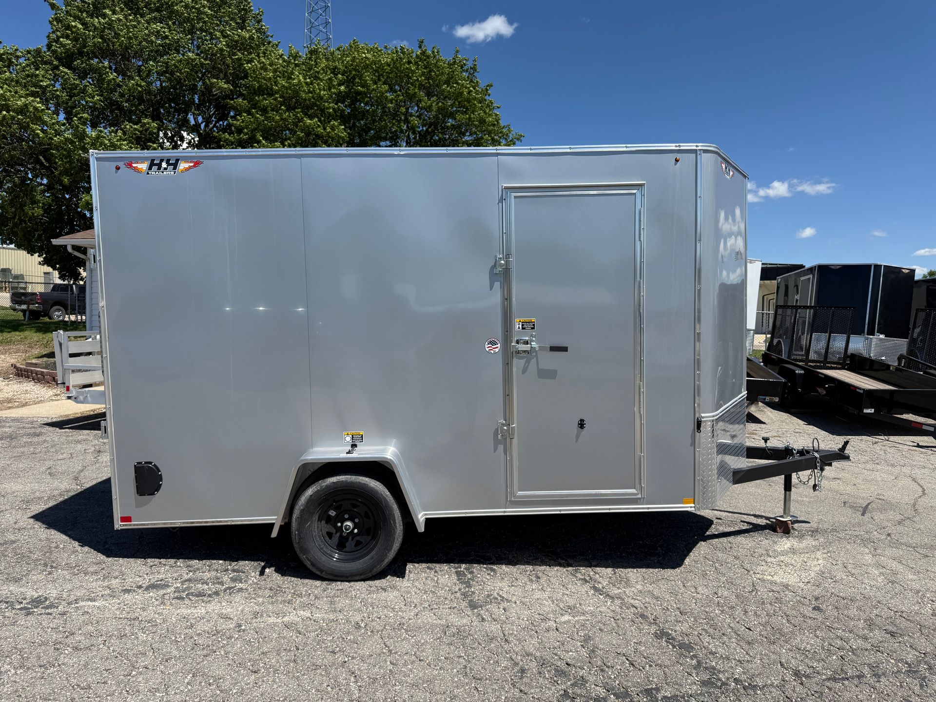 Silver enclosed cargo trailer with diamond plate front panel