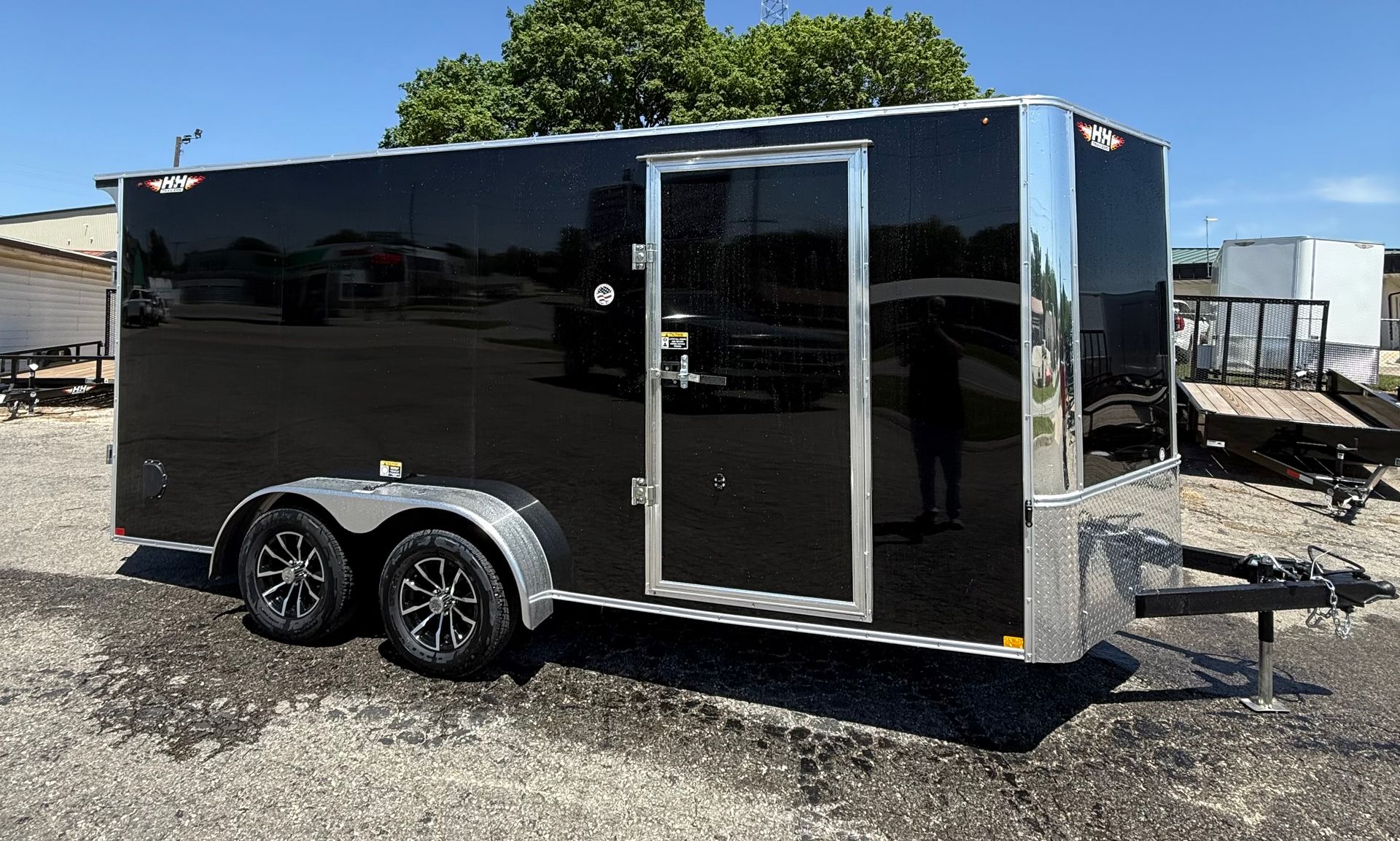 White enclosed cargo trailer with a side door, parked on pavement