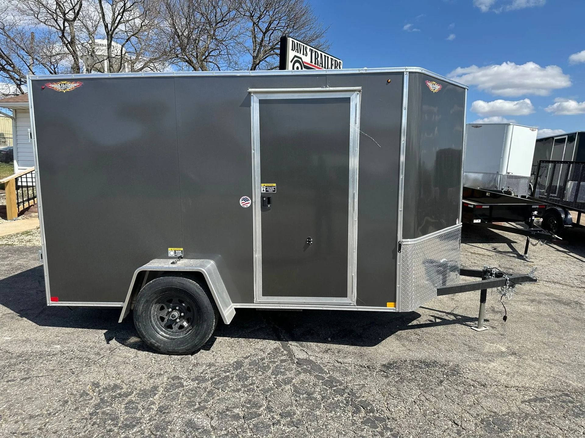 Gray enclosed cargo trailer parked outside on gravel