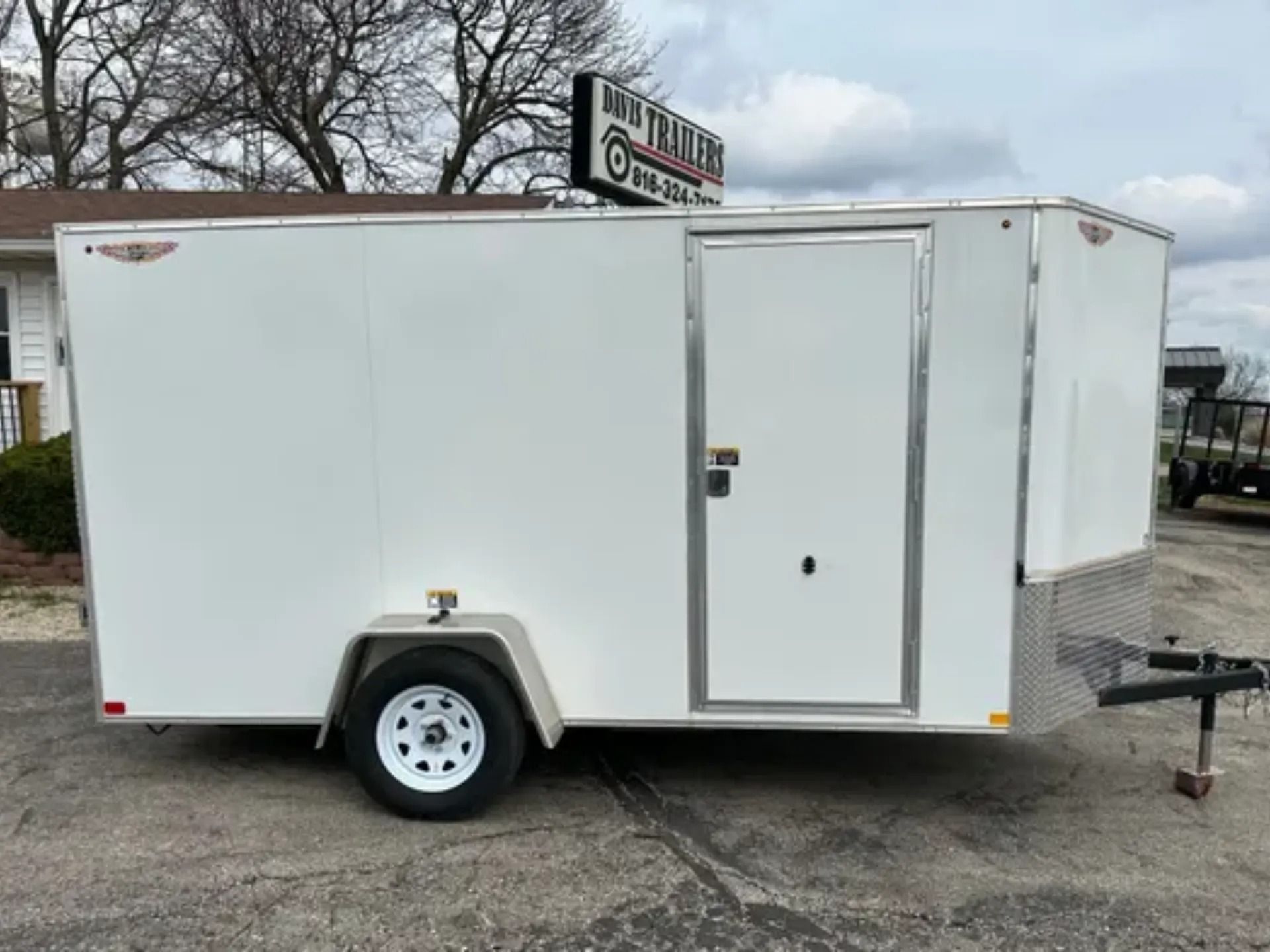 White enclosed cargo trailer with a side door, parked outdoors