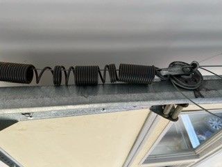 a close up of a broken garage door spring on a garage door .