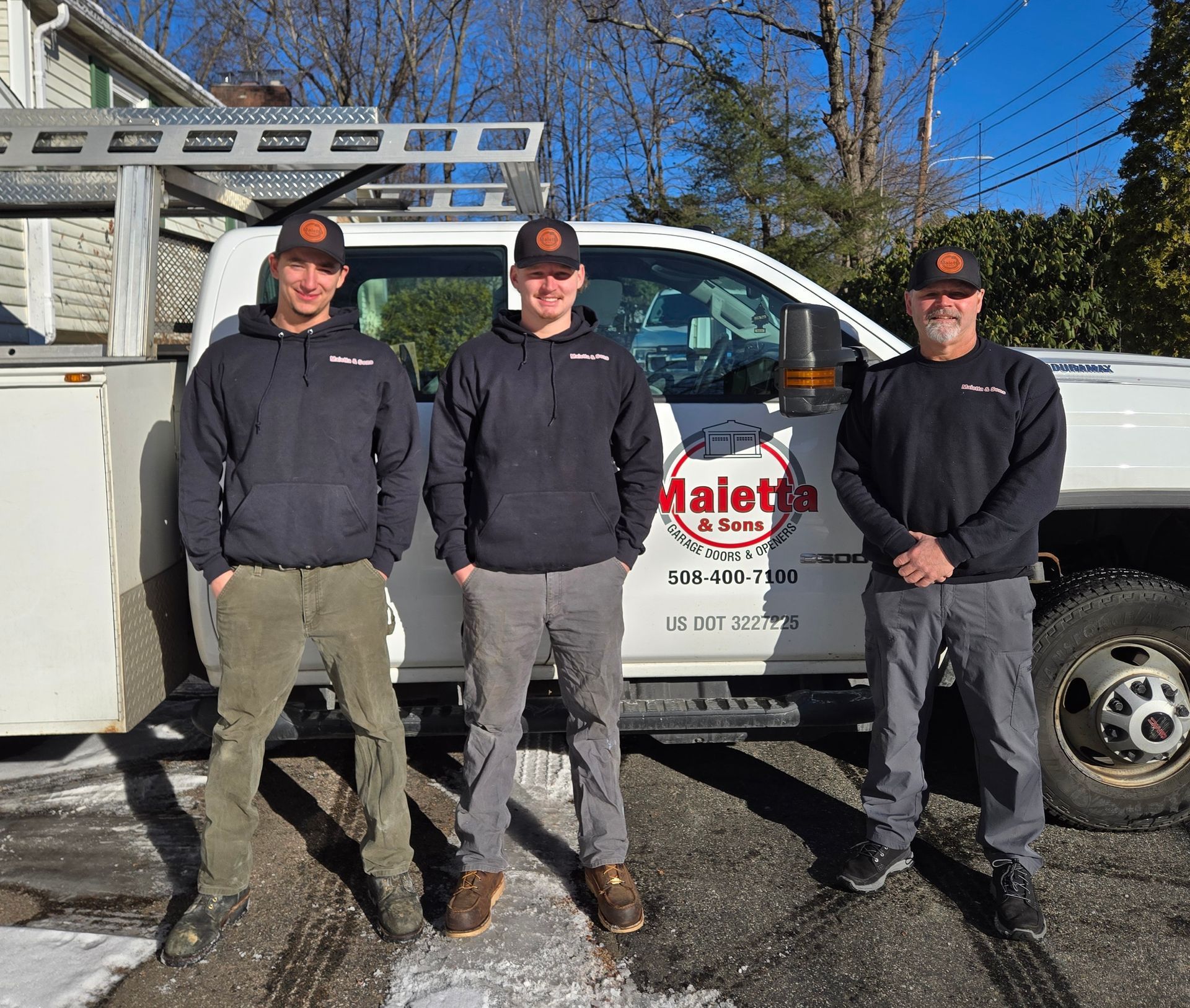 Three men are standing in front of a truck.