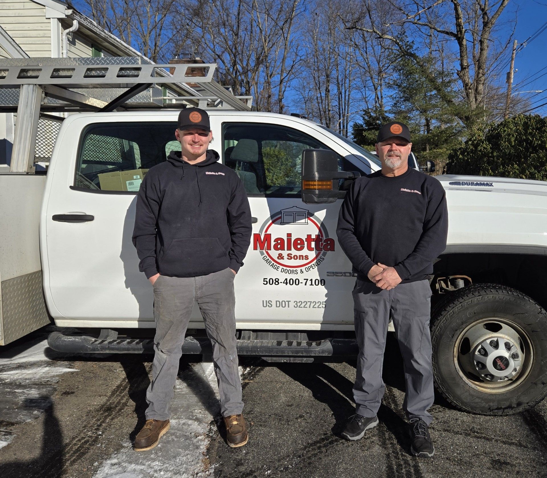 Two men standing in front of a truck.