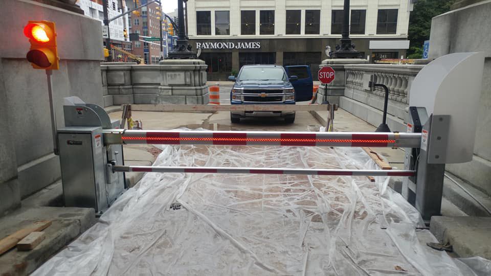 A car is driving through a barrier in a parking garage.