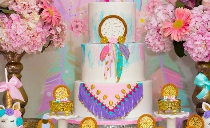 A cake with a dream catcher on it is sitting on top of a table