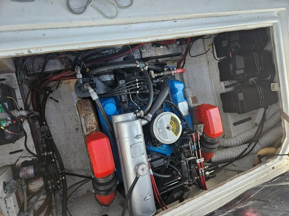 A blue engine is sitting inside of a boat.