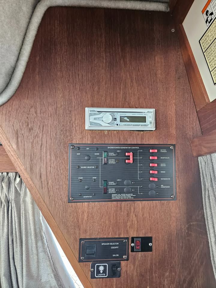 Wooden boat control panel with a radio, digital display, and various switches.