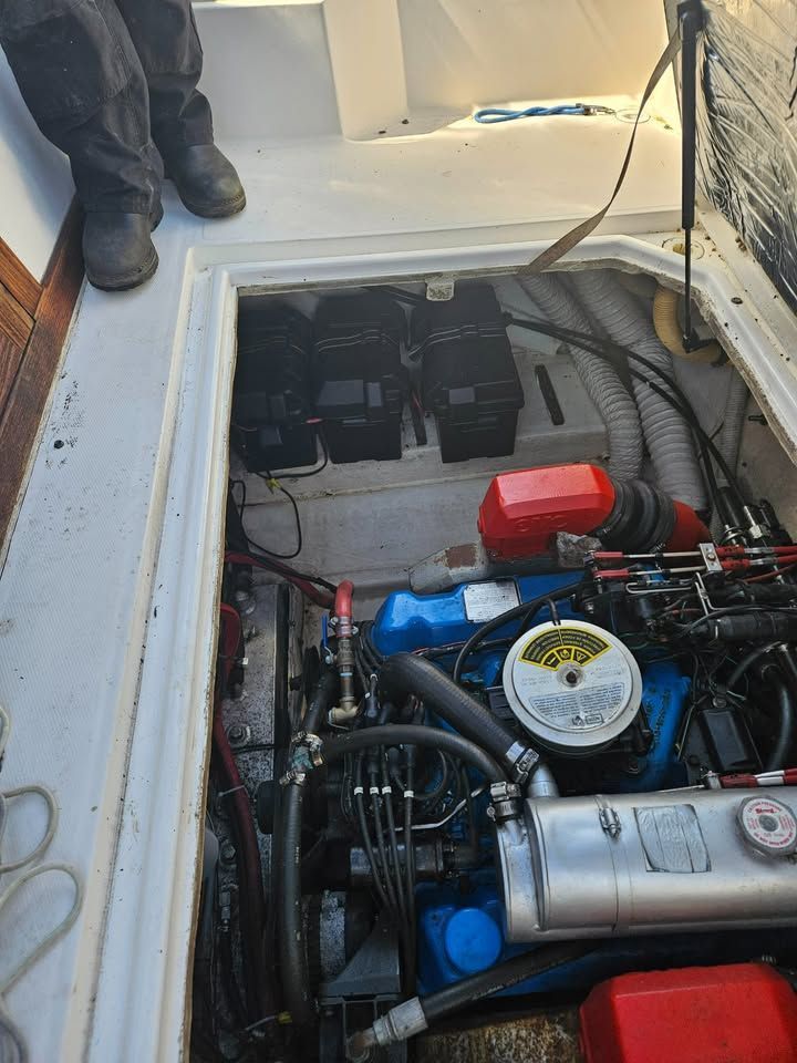 A person is standing in the engine room of a boat.