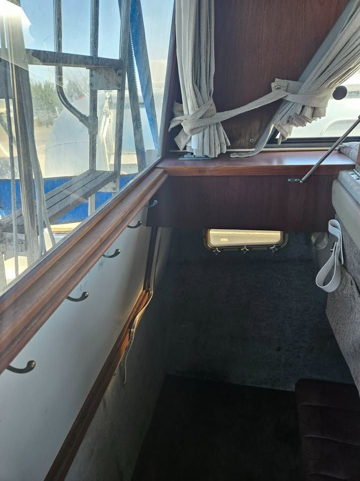 The inside of a boat with a window and stairs.