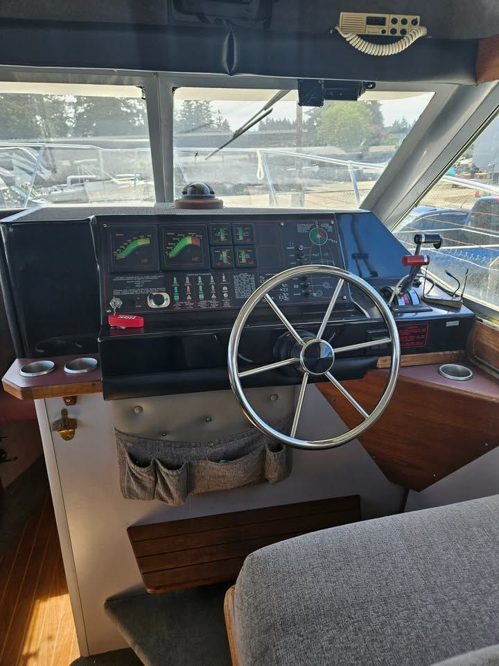 The inside of a boat with a steering wheel and dashboard.