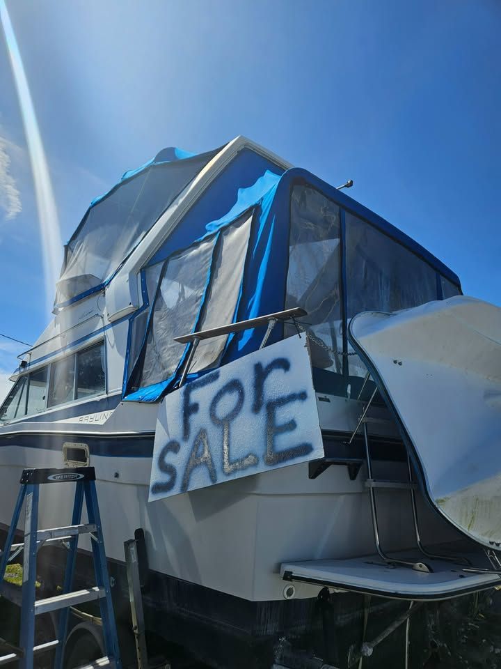 A boat with a for sale sign on the side of it.