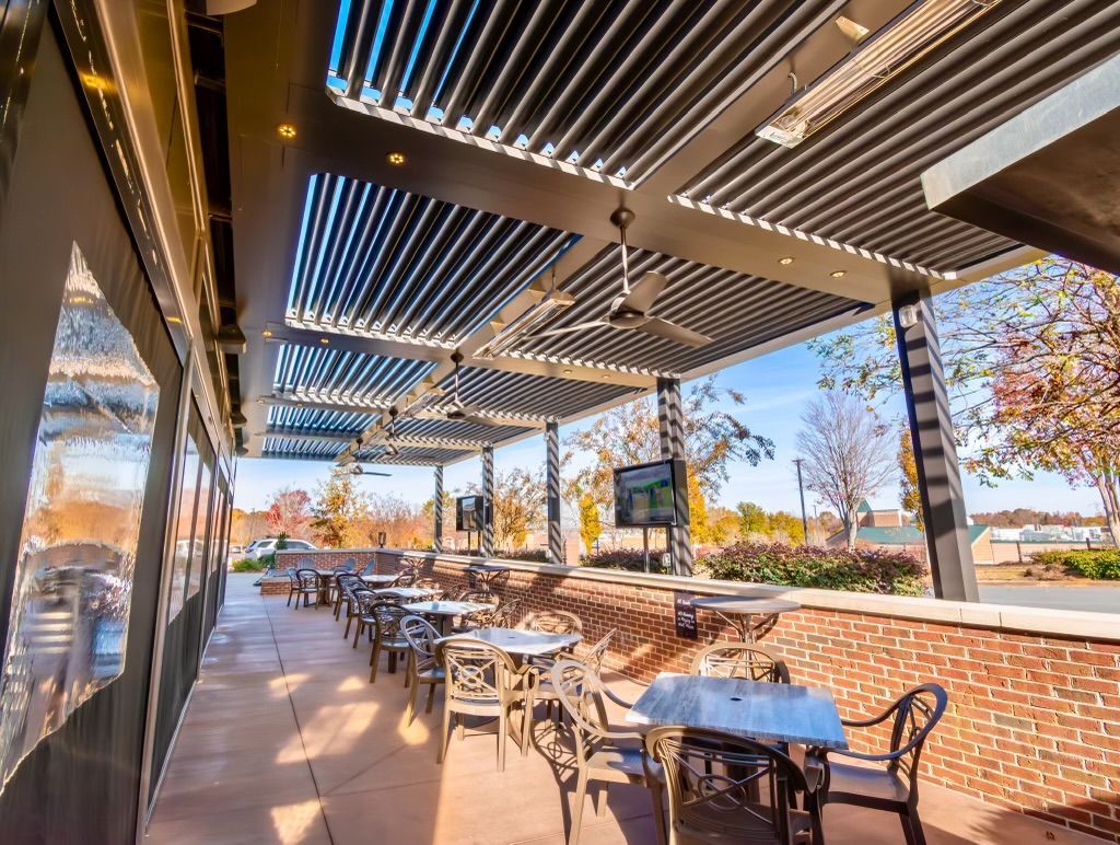 A patio with tables and chairs under a canopy.